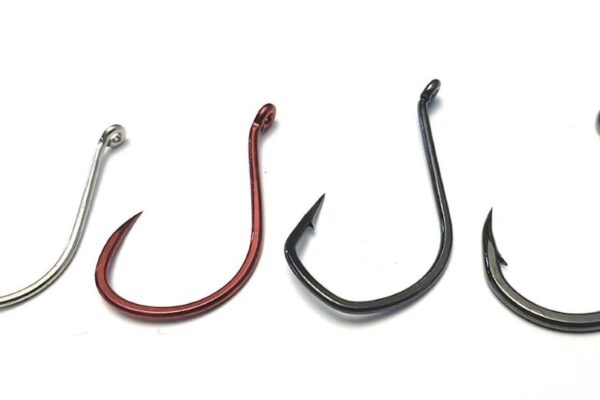 Close-up of three popular fishing hooks—Mustad, Gamakatsu, and VMC—displayed side by side for comparison at the Canadian Fishing Hook Showdown