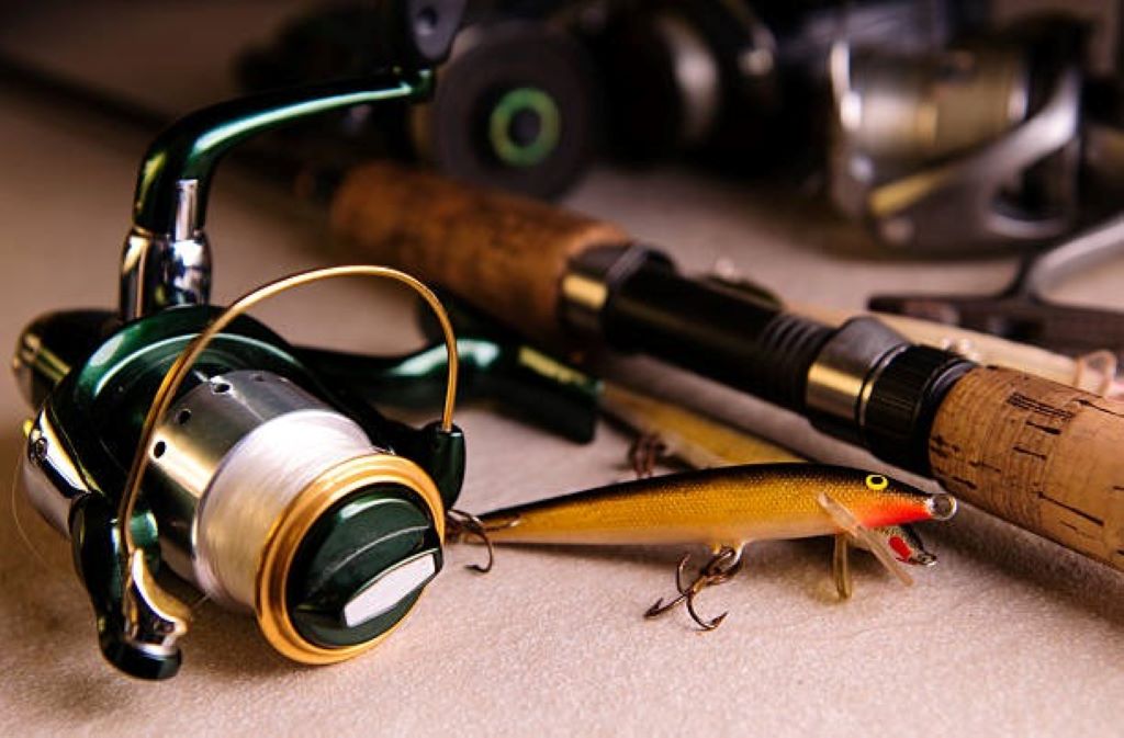 Close-up of several popular Canadian fishing hooks laid out on a table with a fishing enthusiast in the background
