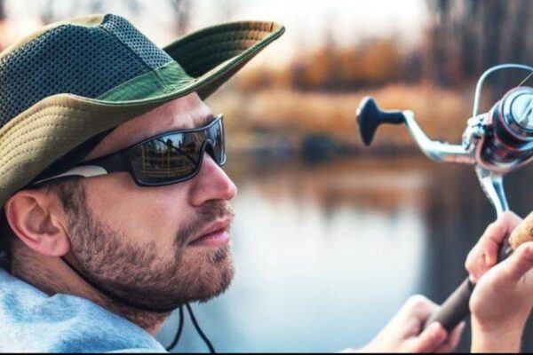 Angler wearing polarized fishing sunglasses on a sunny lake