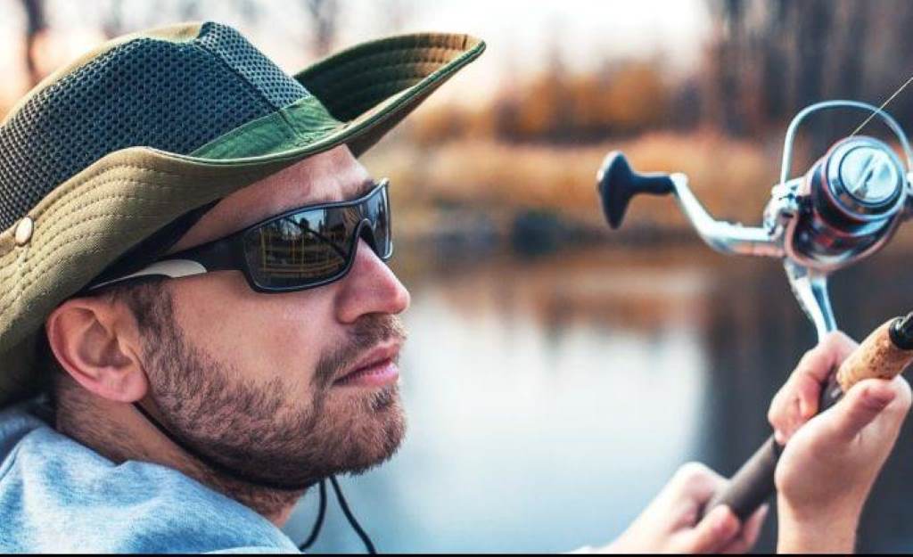 Angler wearing polarized fishing sunglasses on a sunny lake