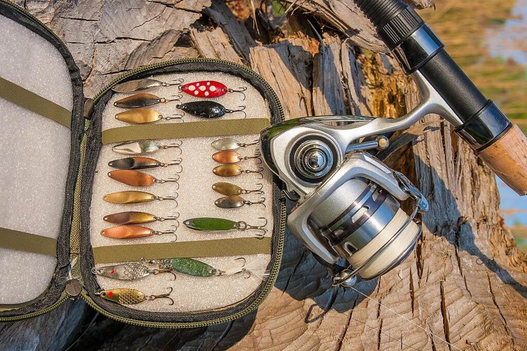 Close up view fishing rod with reel and various baits