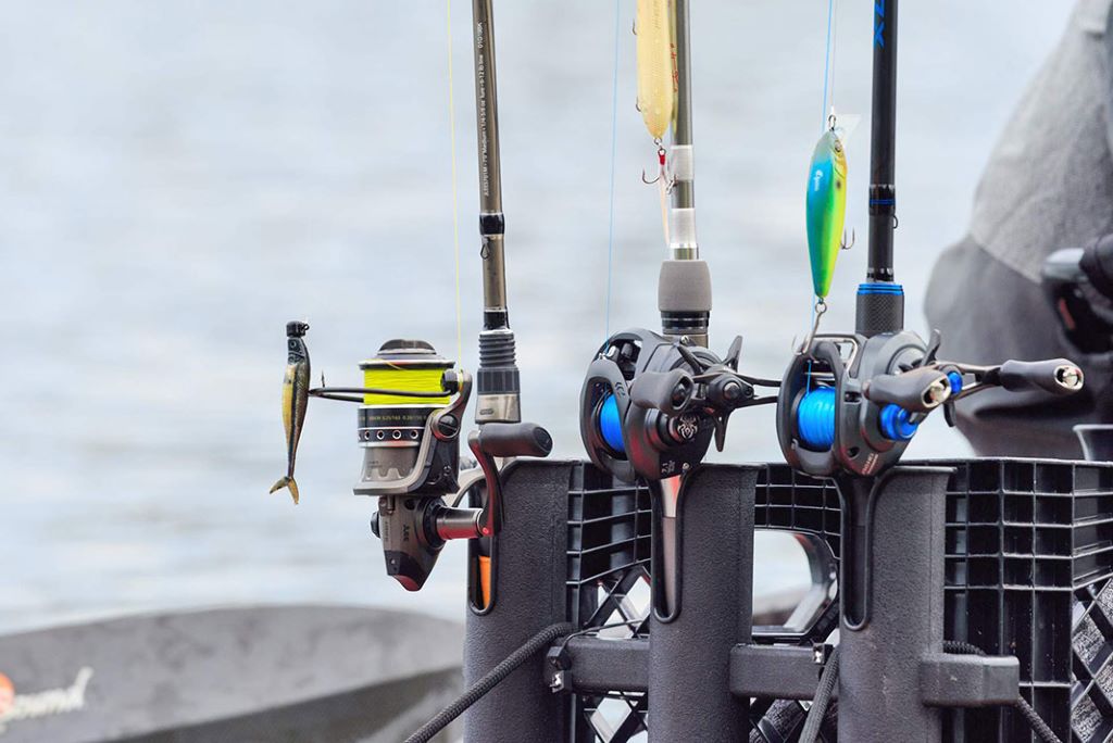 Fishing rod and reel combo set ready for casting on a calm lake at sunrise
