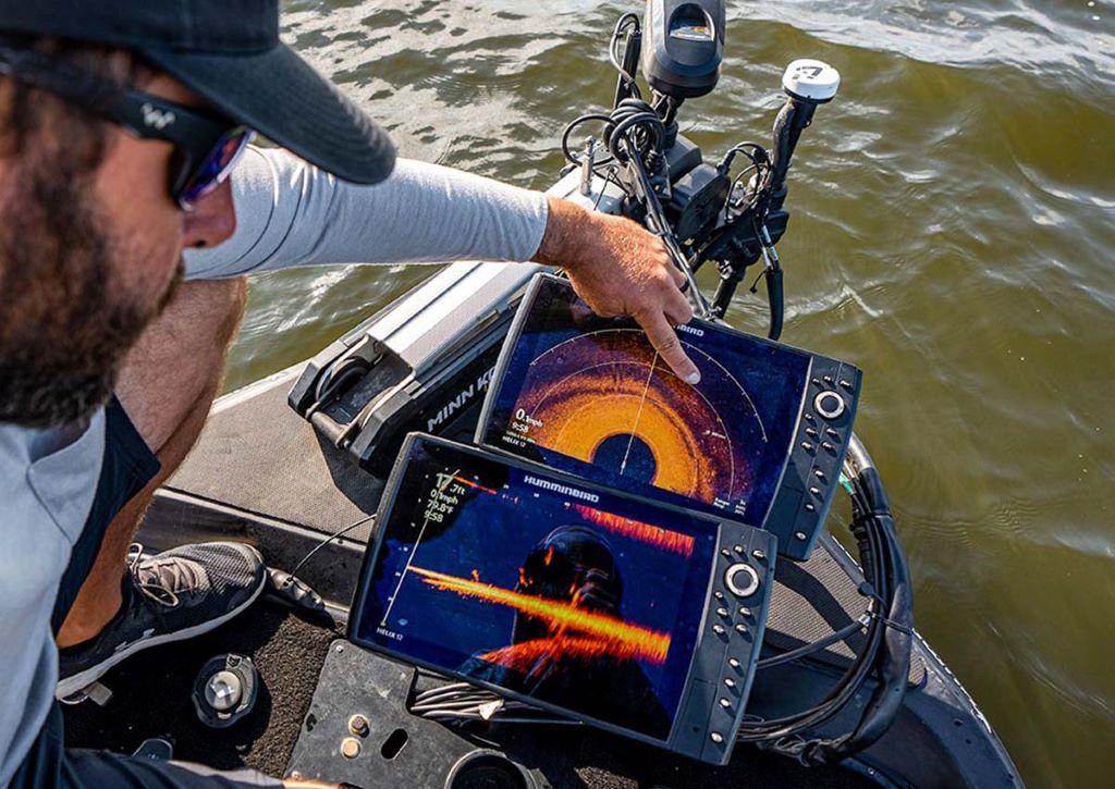 Angler viewing a depth finder screen showing fish and underwater structure for fishing