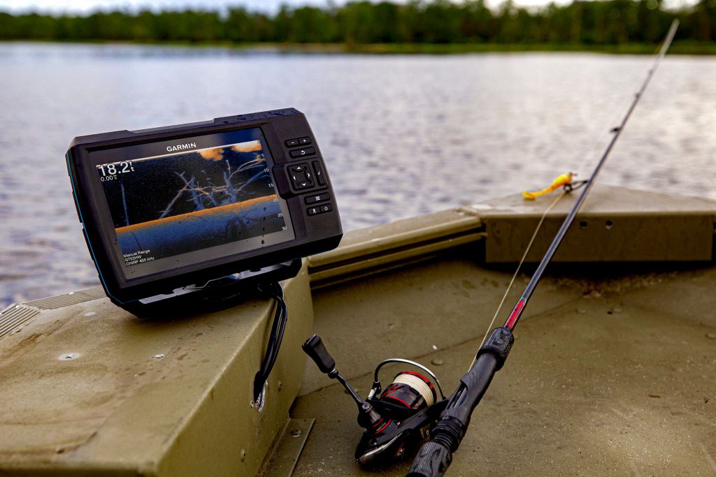 Boat dashboard with depth finder sonar display helping locate fish during a fishing trip