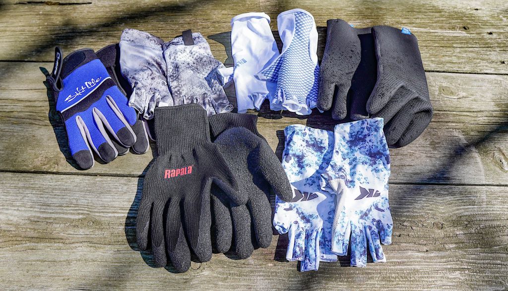 Different fishing gloves designed for grip, comfort, and protection displayed on a table